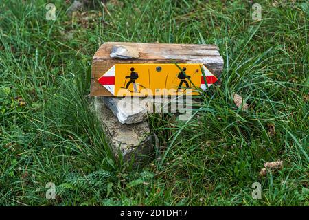 Hiking trail sign in the grass of an alpine pasture. Impressions in the Ticino Muggio Valley, Breggia, Switzerland Stock Photo