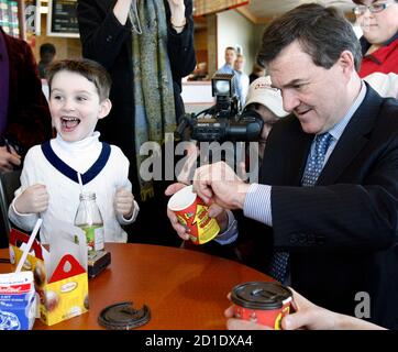 Six year-old Nathaniel Baturensky (L) reacts as Canada's Finance Minister Jim Flaherty 'rolls up the rim to win' during a photo opportunity at a fast food restaurant the day after delivering a family-friendly budget in Whitby, March 20, 2007.     REUTERS/J.P. Moczulski (CANADA)