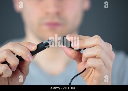 administrator holding network cables connected to servers Stock Photo