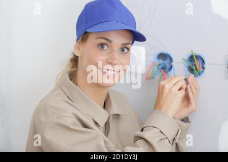 happy female electrician fixing electricity problem Stock Photo