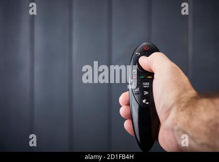 Modern remote control of a television held by a hand of a white or Caucasian male Stock Photo