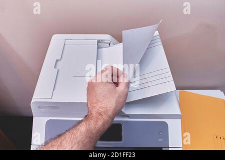 A person is making photocopies or printing documents in an office Stock Photo