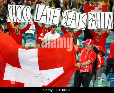Switzerland's fans hold a national flag and banners as they celebrate after their win against Spain at the end of a 2010 World Cup Group H match at Moses Mabhida stadium in Durban June 16, 2010.   REUTERS/Paul Hanna (SOUTH AFRICA  - Tags: SPORT SOCCER WORLD CUP)
