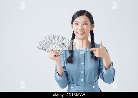 Portrait of happy woman holding and pointing finger fan of money isolated over white background Stock Photo