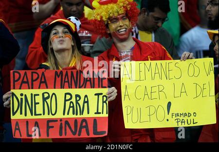 Spain fans hold up signs before the 2010 World Cup semi-final soccer match between Germany and Spain at Moses Mabhida stadium in Durban July 7, 2010. The sign on the left reads: 'Dad, send me money to go to the final.' The sign on the right reads: 'Germans, the Octopus' prediction will come true.' REUTERS/Siphiwe Sibeko (SOUTH AFRICA  - Tags: SPORT SOCCER WORLD CUP)