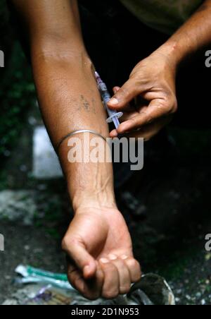 An injecting drug user (IDU) injects himself with heroin, locally known as brown sugar, by a roadside in the eastern Indian city of Siliguri June 25, 2009. The United Nations observes International Day against Drug Abuse and Illicit Trafficking on June 26. REUTERS/Rupak De Chowdhuri (INDIA SOCIETY HEALTH)
