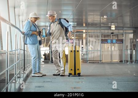 Senior lady suffering from stomach ache at the airport Stock Photo