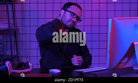 A programmer working on his computer having pain in his neck. Stock Photo