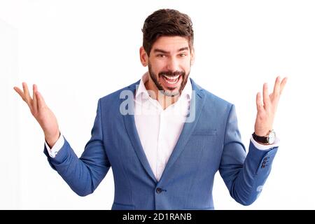 Portrait shot of cheerful young businessman with spread open arms looking at camera and smiling while standing at isolated white background. Stock Photo