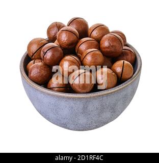 macadam nuts in bowl with clipping path on a white isolated background Stock Photo