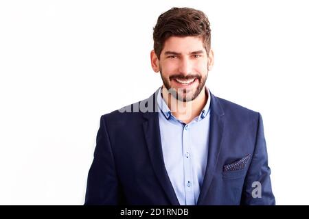 Portrait shot of cheerful young businessman wearing suit and looking at camera while standing at isolated white background. Stock Photo