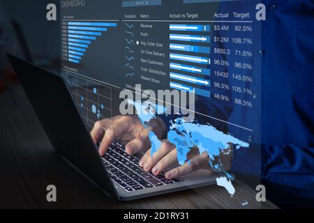 Manager analyzing business analytics dashboard with operations and sales metrics on computer. Late night overtime in office. Key performance indicator Stock Photo