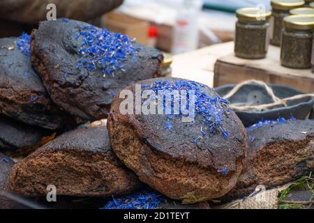 Homemade black cereal and juniper bread with hemp seeds in a street food traditional market Stock Photo