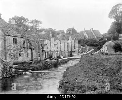 ARLINGTON ROW, Bibury, Gloucestershire. Looking up the well-known row of Cotswold stone cottages on the river Coln. These were converted into dwellings in the early 17th century from a monastic sheephouse dating to c.1380 with ten bays of cruck trusses. Photographed in 1901 by Henry Taunt. Stock Photo