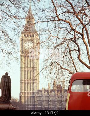 PALACE OF WESTMINSTER, London. The clock tower of the Houses of Parliament viewed from Parliament Square. The huge bell housed in the clock tower and known as Big Ben came into operation in 1859. A red London bus is passing. Photographed by Eric de Mare between 1945 and 1980. Stock Photo