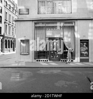 YARDLEY, 33 Old Bond Street, Westminster, London. An elegantly dressed young woman looks into the shop front of Yardley, the cosmetics brand. Yardley of London was established in 1770 and moved to Bond Street in 1910. Photographed in 1948 by M Lynn Jenkins. Stock Photo