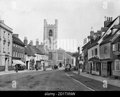 HENLEY-ON-THAMES, Oxfordshire. View of St Marys Church, looking down Hart Street towards the distinctive flint and stone chequer patterned church tower with polygonal angle buttresses, dating to the 16th century. On the right are some timber-framed town houses with dormer windows. Photographed by Henry Taunt in 1890. Stock Photo