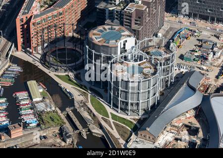 Gasholders Nos. 10, 11 and 12, also known as the 'Siamese Triplet' restored and re-erected around a series of apartment buildings and St Pancras Lock, Kings Cross, London, 2018, UK. Aerial view. Stock Photo