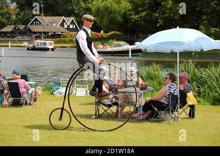 A man riding a vintage penny-farthing bicycle at the Traditional Boat Festival in Henley-on-Thames, Oxfordshire, UK Stock Photo