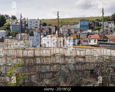 General view looking north-west past piles of lobster pots on the Stade beach towards East Beach Street, with houses on the hillside beyond, The Stade, Hastings, East Sussex, UK. Stock Photo