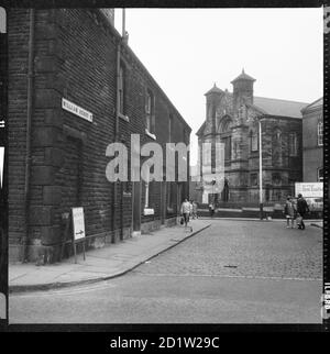 A view from the junction of Oldham Road looking west along William Henry Street towards Trinity Methodist Church with numbers 1, 3 and 5 in the foreground, Rochdale, Greater Manchester, UK. Stock Photo