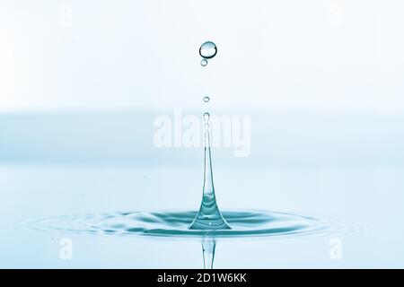 Water splash of falling drop with circular waves Stock Photo