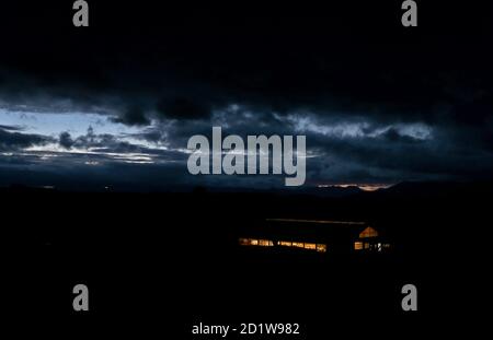 06 October 2020, Bavaria, Oy-Mittelberg: Cows stand in the stable of a farm just before sunrise in front of the cloudy Alps. Photo: Karl-Josef Hildenbrand/dpa Stock Photo