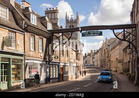 High Street St Martin's, Stamford Baron, Stamford, South Kesteven, Lincolnshire. General view looking south along the street, with the George Hotel's road-spanning sign in the foreground. Stock Photo