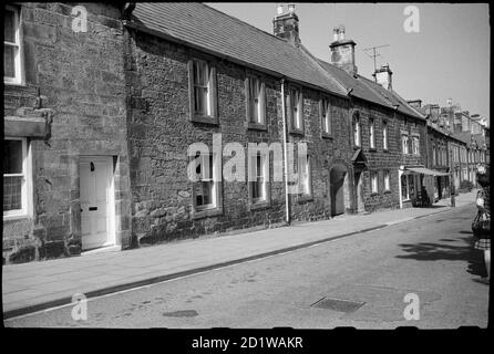 Ogle House, High Street, Rothbury, Northumberland. An exterior view of the front elevations of houses on High Street, showing Ogle House with a carriage arch entrance, and West End House further in the background, and looking east. Stock Photo