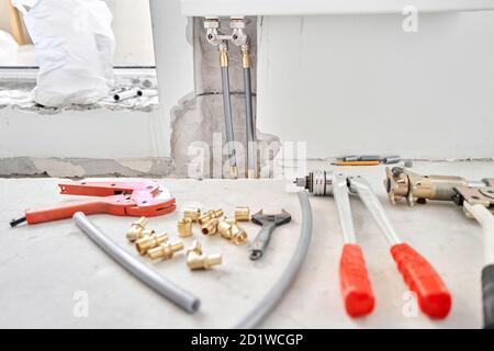 Tools for Work As A Plumber. Connection heating pipes to white Radiator in a new apartment under construction. water heating radiator on the white Stock Photo