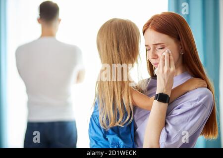 redhead caucasian woman with child girl leave man, he turned away from his family, cheated on his wife, he has a mistress Stock Photo