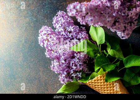 Beautiful lilac flowers in an ice cream waffle cup. Can be used for greeting card. Stock Photo