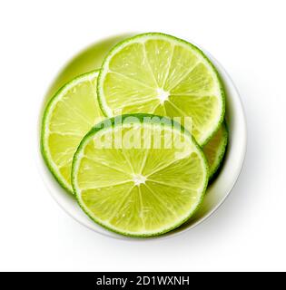 White bowl of lime slices isolated on white background, top view Stock Photo
