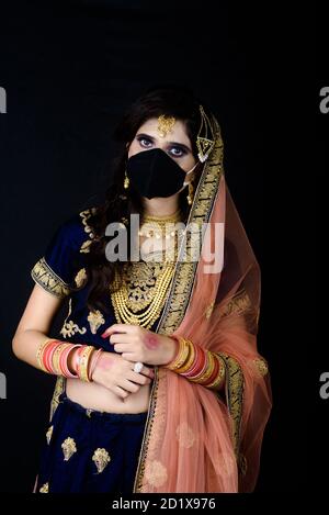 Bride wearing white Indian traditional cloth with face mask during wedding celebration in India Stock Photo