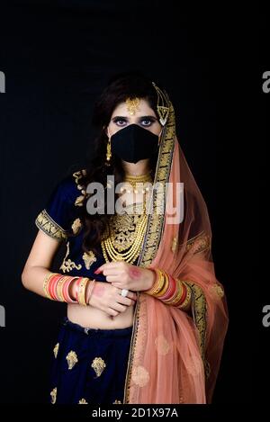 Bride wearing white Indian traditional cloth with face mask during wedding celebration in India Stock Photo