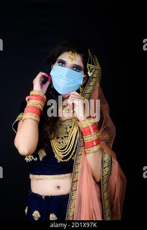 Bride wearing white Indian traditional cloth with face mask during wedding celebration in India Stock Photo