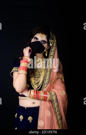 Bride wearing white Indian traditional cloth with face mask during wedding celebration in India Stock Photo