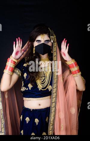 Bride wearing white Indian traditional cloth with face mask during wedding celebration in India Stock Photo