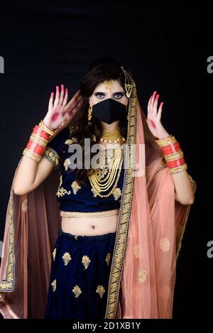 Bride wearing white Indian traditional cloth with face mask during wedding celebration in India Stock Photo