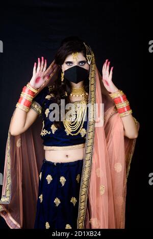 Bride wearing white Indian traditional cloth with face mask during wedding celebration in India Stock Photo