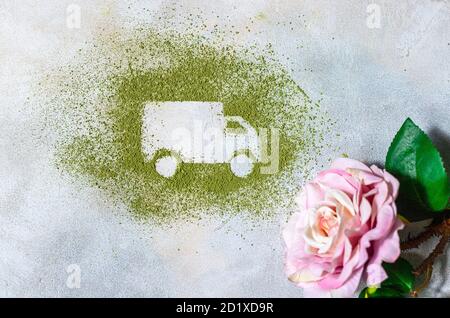 Car made of green powder and rose on a light background. Online shopping. Flowers delivery concept. Stock Photo