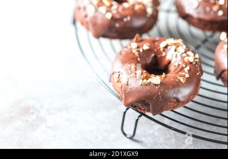 Chocolate donuts on a light concrete background. National Donut Day. Homemade baking. Stock Photo