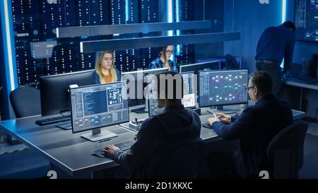 Team of IT Programers Working on Desktop Computers in Data Center System Control Room. Team of Young Professionals Working In Software and Hardware Stock Photo