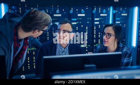 Male and Female IT Engineers Programmers Having Discussion about Coding on Desktop Computers. Technical Department with Data Server Racks. Software Stock Photo