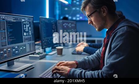 Software Developer Programming, Finding Solutions while Working on Desktop Computers in Data Center System Control Room. Team of Young Professionals Stock Photo