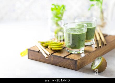 Detox green smoothie - kiwi, spinach and matcha on a light grey slate, stone or concrete background. Stock Photo