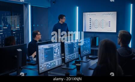 Team of Professional IT Developers Have a Meeting, Speaker Talks about New Blockchain Based Software Development Shown on TV. Concept: Deep Learning Stock Photo