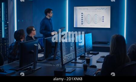 Team of Professional IT Developers Have a Meeting, Speaker Talks about New Blockchain Based Software Development Shown on TV. Concept: Deep Learning Stock Photo