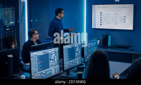 Team of Professional IT Developers Have a Meeting, Speaker Talks about New Blockchain Based Software Development Shown on TV. Concept: Deep Learning Stock Photo
