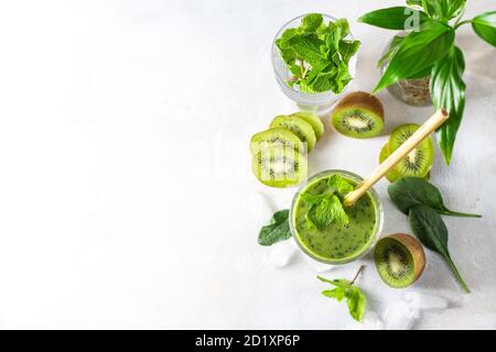 Detox green smoothie - kiwi, spinach and matcha on a light grey slate, stone or concrete background. Stock Photo